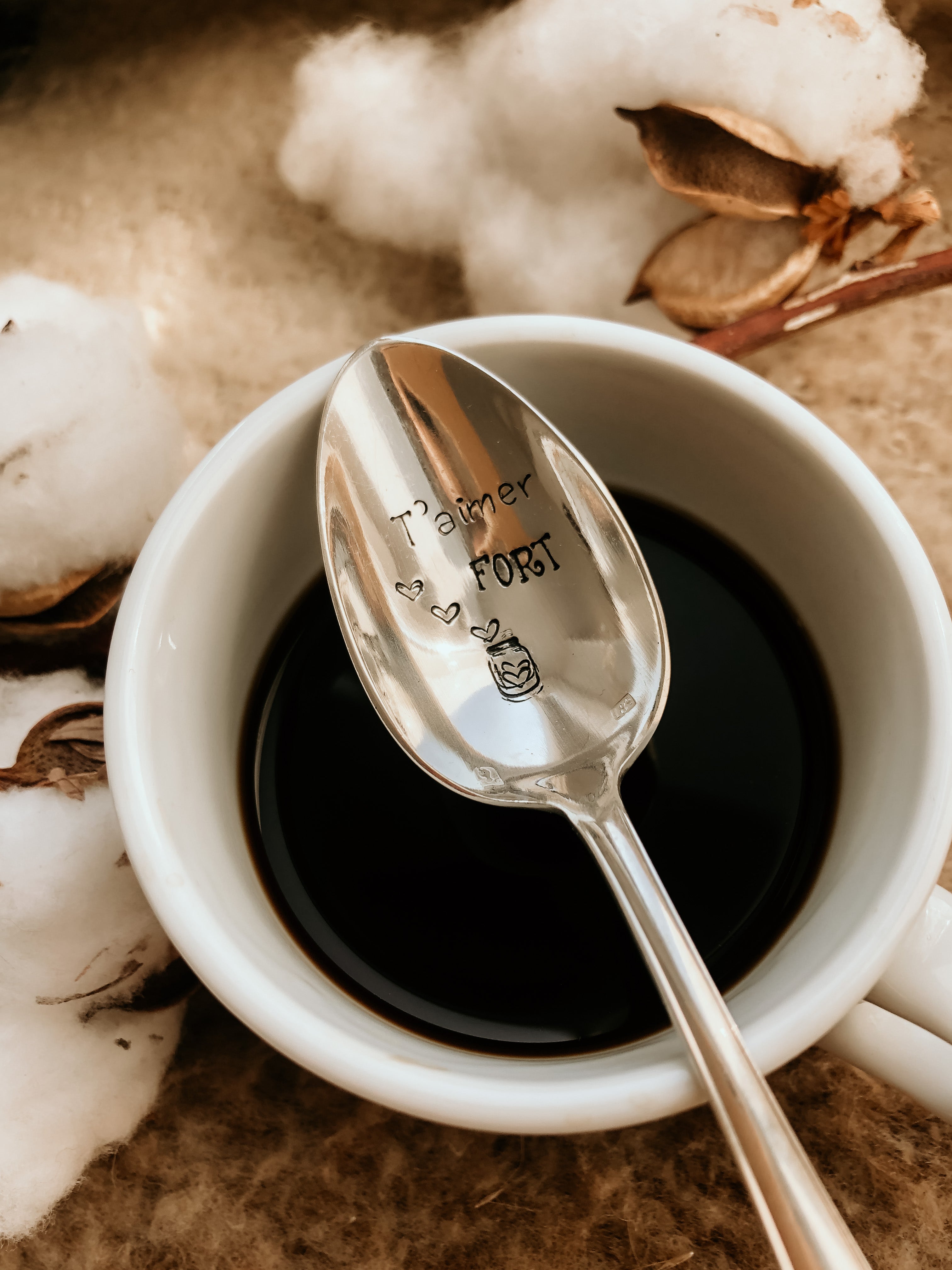 Cuillère à café gravée "t'aimer fort" dans une tasse de café 
