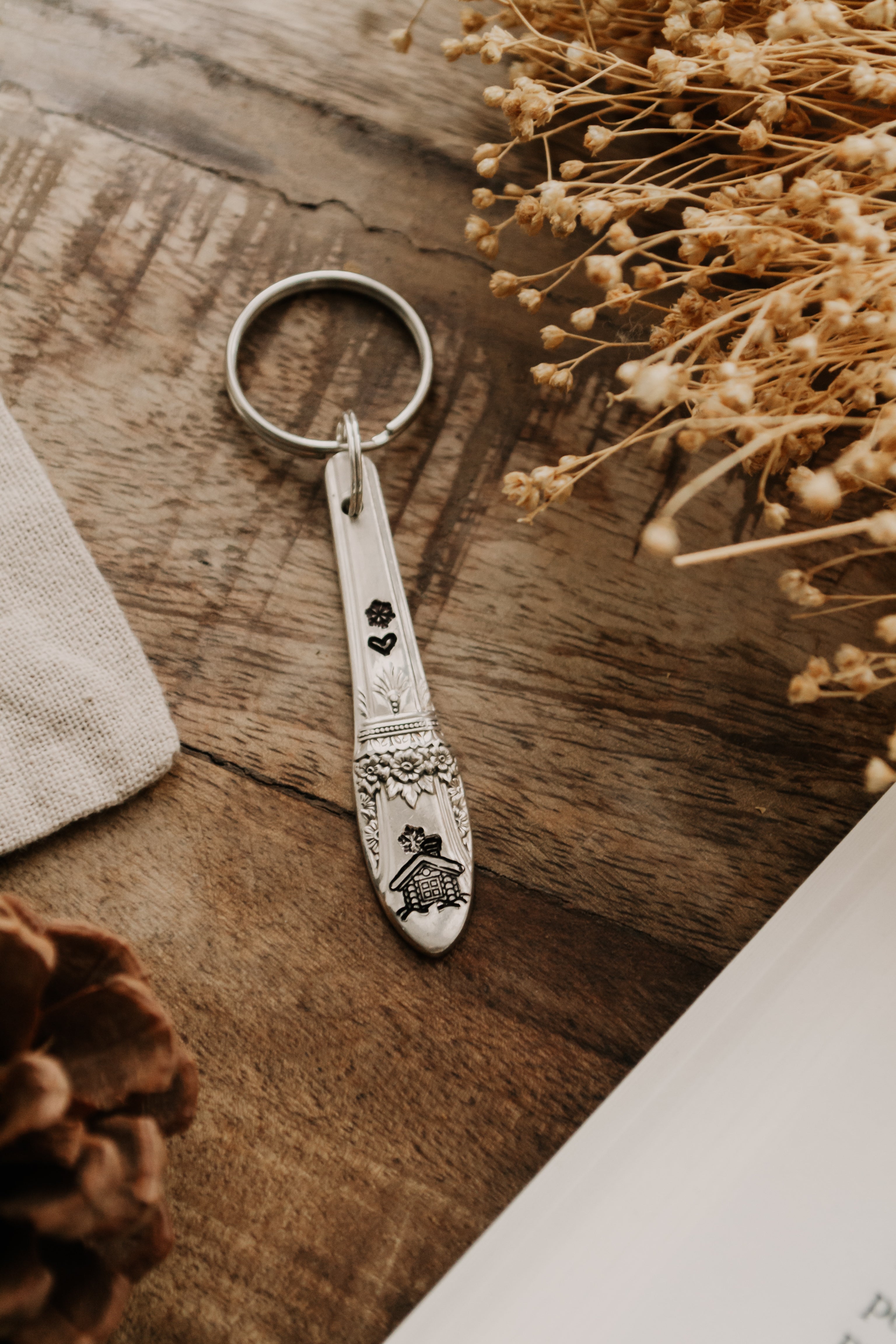 Porte-clé fleuri "chalet sous la neige" - sous le sable design - grisbleu