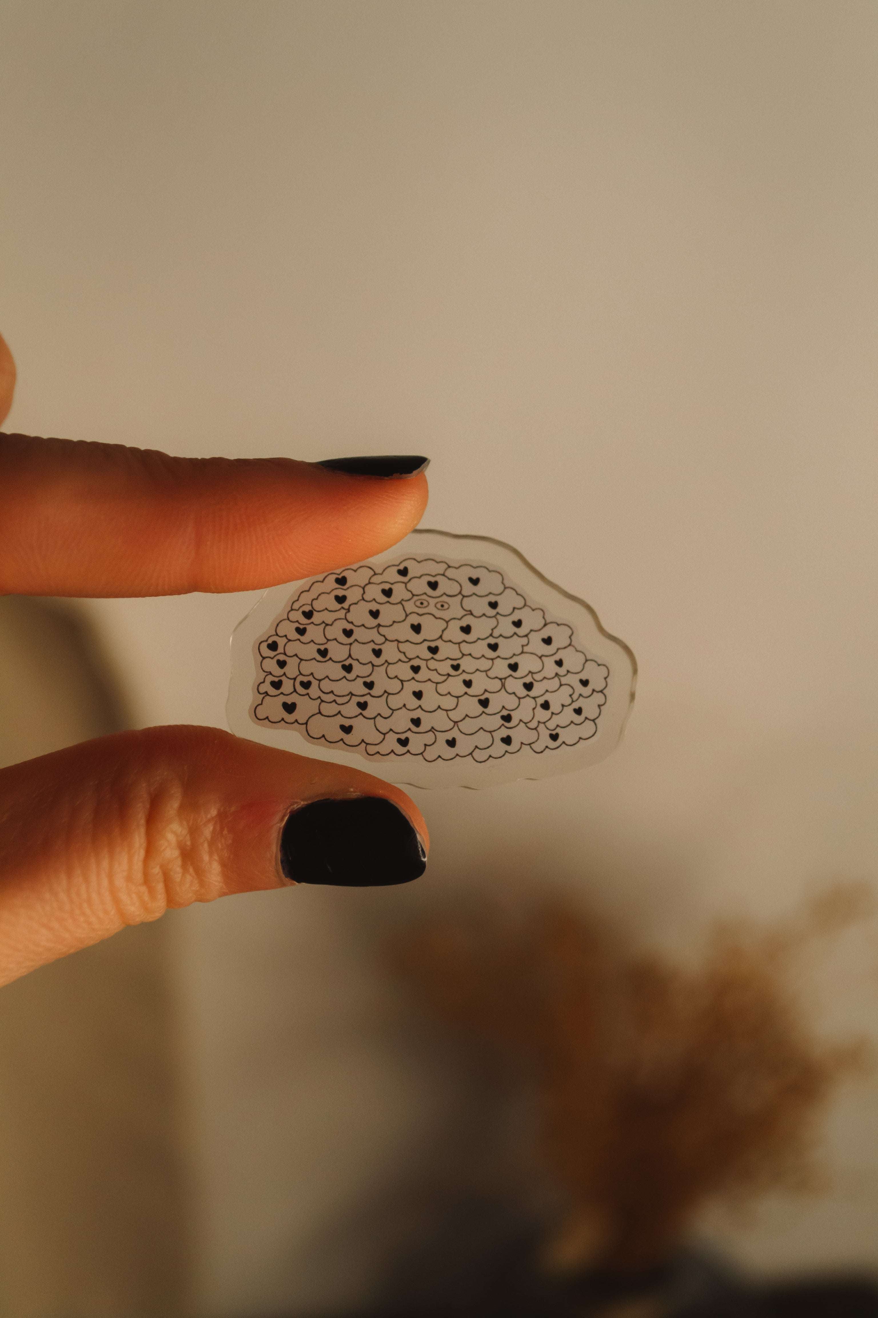 Main qui tient pins en acrylique - bonhomme sous une pluie de coeurs